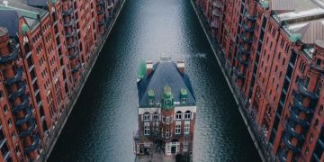 The Wasserschloss in the middle of a canal between the row of historic warehouses in Speicherstadt